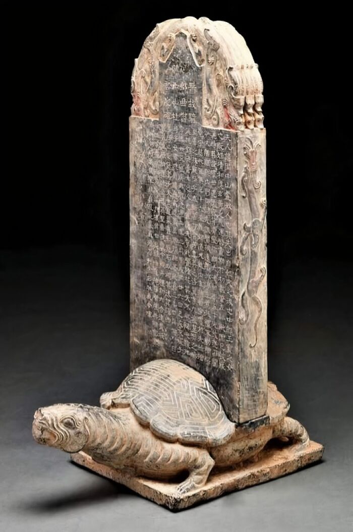 Stone tablet with carved text on a turtle base, revealing secrets of ancient civilizations.