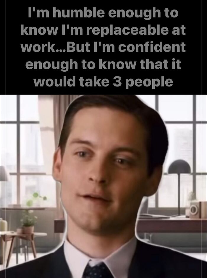 Man in an office with a confident smile, caption about feeling replaceable and irreplaceable, related to funny work memes.