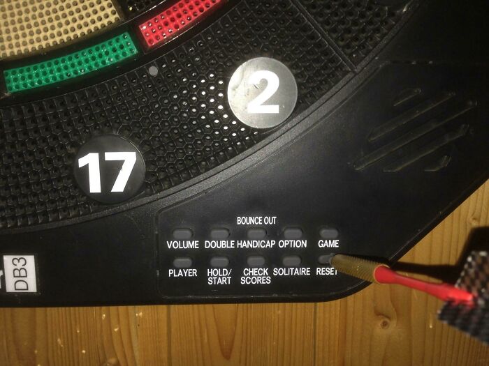Electronic dartboard with buttons for game options and a visible dart in the board.