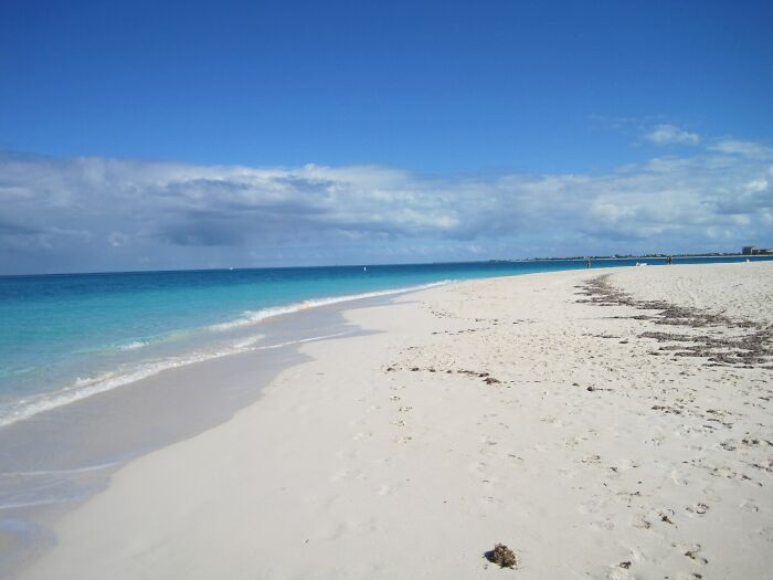 Gorgeous beach with pristine white sand and clear blue water under a bright sky.