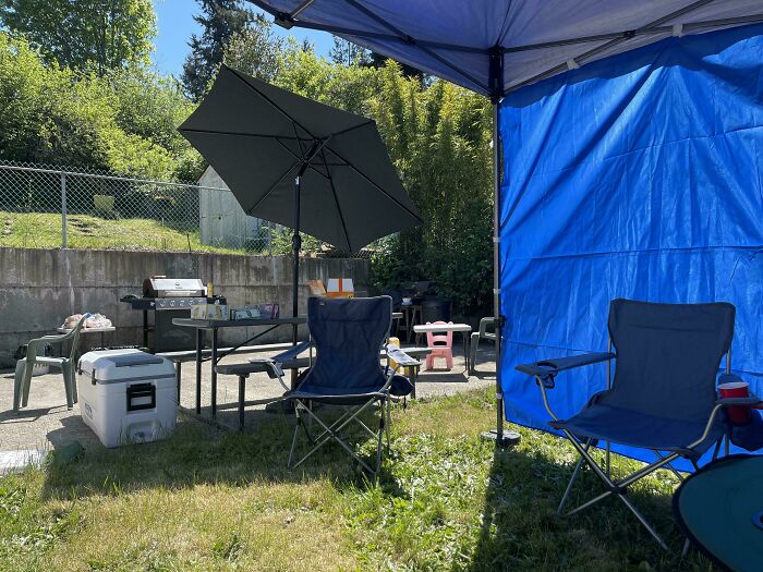 Silla de camping y sombrilla en jardín con ambiente tranquilo, ideal para personas teniendo un mal día al aire libre.