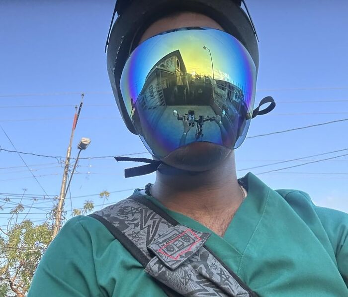 Person in helmet and reflective visor, capturing street view, embodying unique Amazon finds.