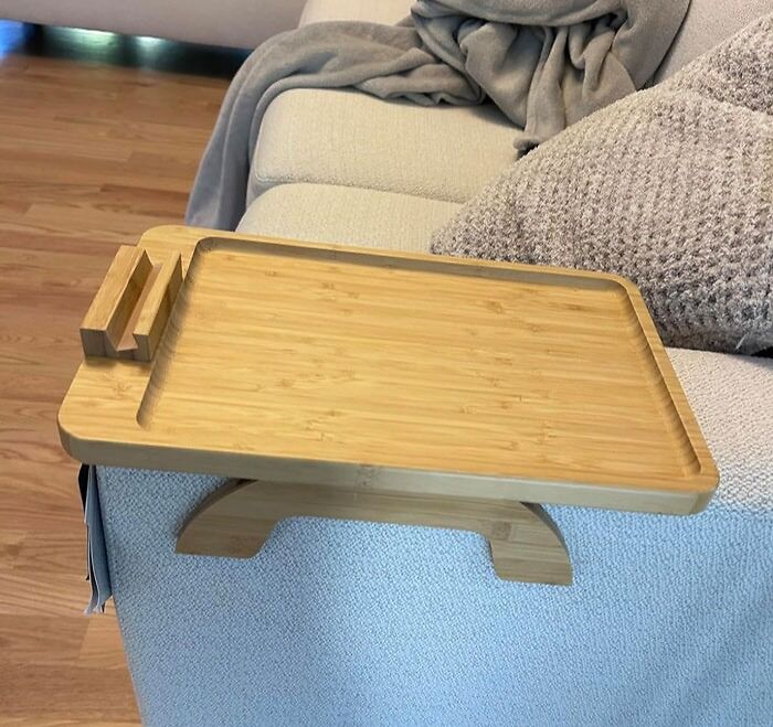 Bamboo couch tray on a sofa, ideal for living room convenience; a love-at-first-sight find.