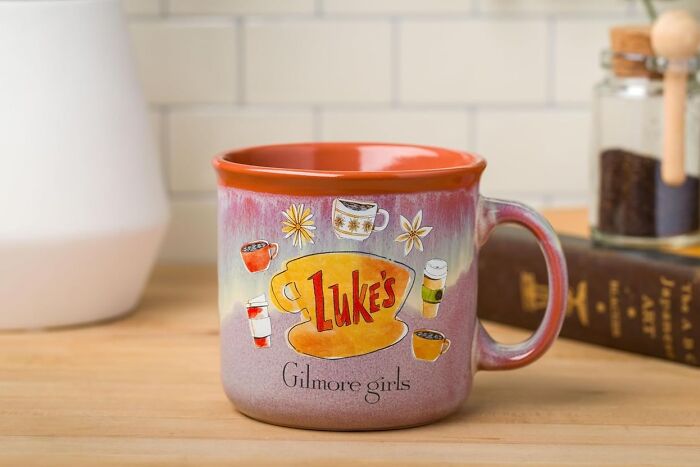 Mug with "Luke's" logo from Gilmore Girls, showcasing pure fandom goals on a wooden table.
