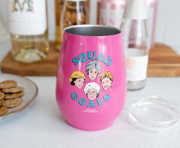 Pink cup with "Squad Goals" text and cartoon faces, showcasing pure fandom.