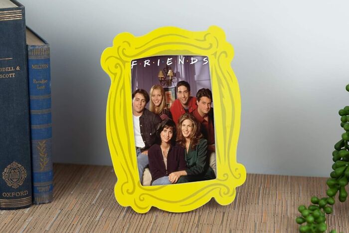 Yellow Friends-themed frame with iconic photo, perfect for fandom enthusiasts, placed on a desk.
