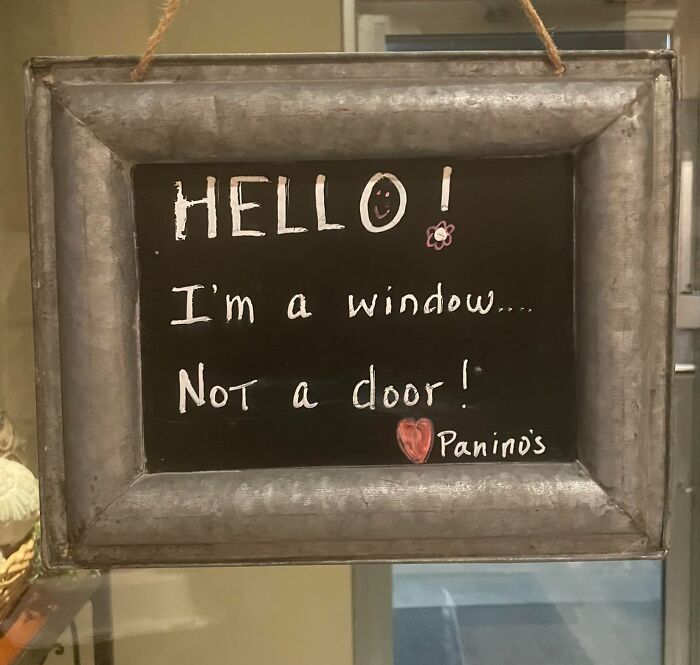 Sign with text, "I'm a window... Not a door!", highlighting a quirky mistake aftermath with humor.