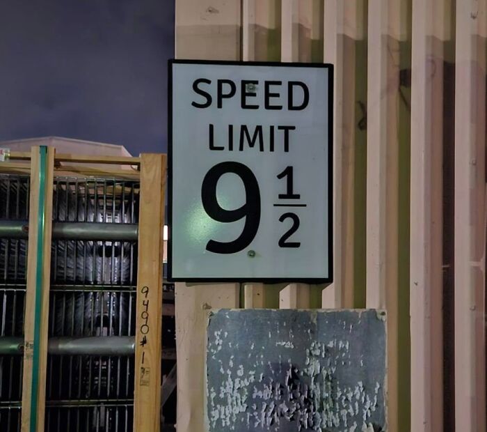 Speed limit sign showing 9 1/2 in an industrial setting, highlighting a unique warning sign.