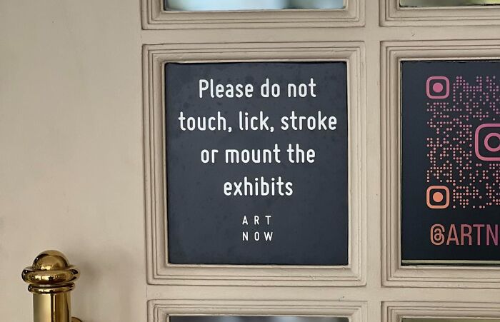 Art exhibit warning sign stating not to touch, lick, stroke, or mount the exhibits, with accompanying QR code.