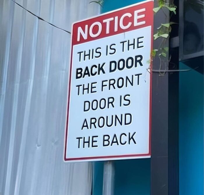 Notice sign humorously indicating back door locations, creating a confusing message.