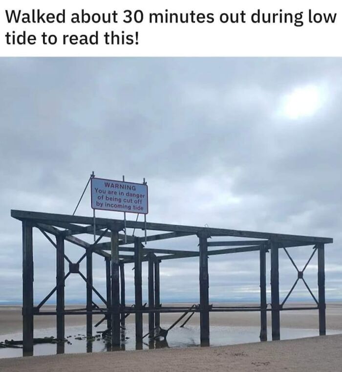 Warning sign on a beach structure about incoming tide, highlighting aftermath of a mistake in low tide timing.
