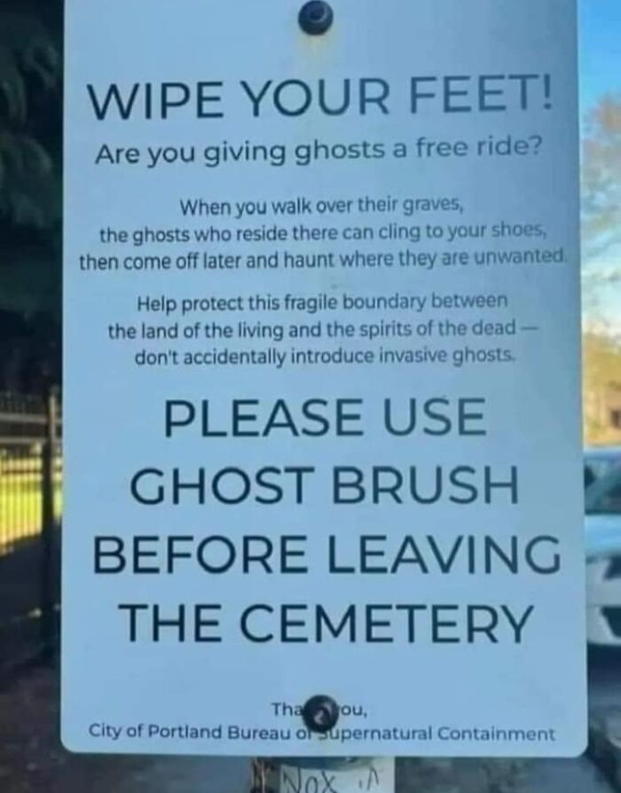 Sign warning about ghost contamination at cemetery exit.