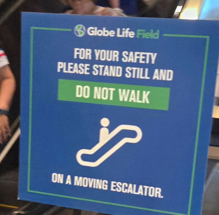 Safety sign on escalator at Globe Life Field, warning to stand still and not walk.