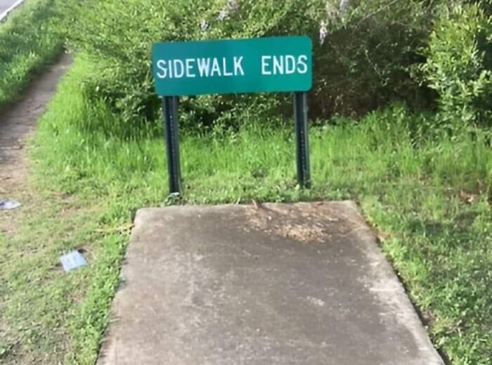 Sidewalk abruptly ends with a sign, highlighting a possible mistake in path design.