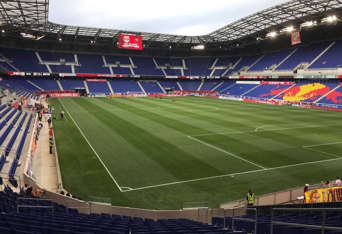 Modern soccer stadium with empty seats and a large green field, one of the iconic cathedrals of soccer.