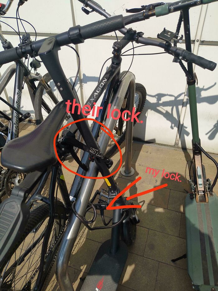 Bicycle locked improperly with two locks, labeled "their lock" and "my lock," capturing a humorous parking mistake.