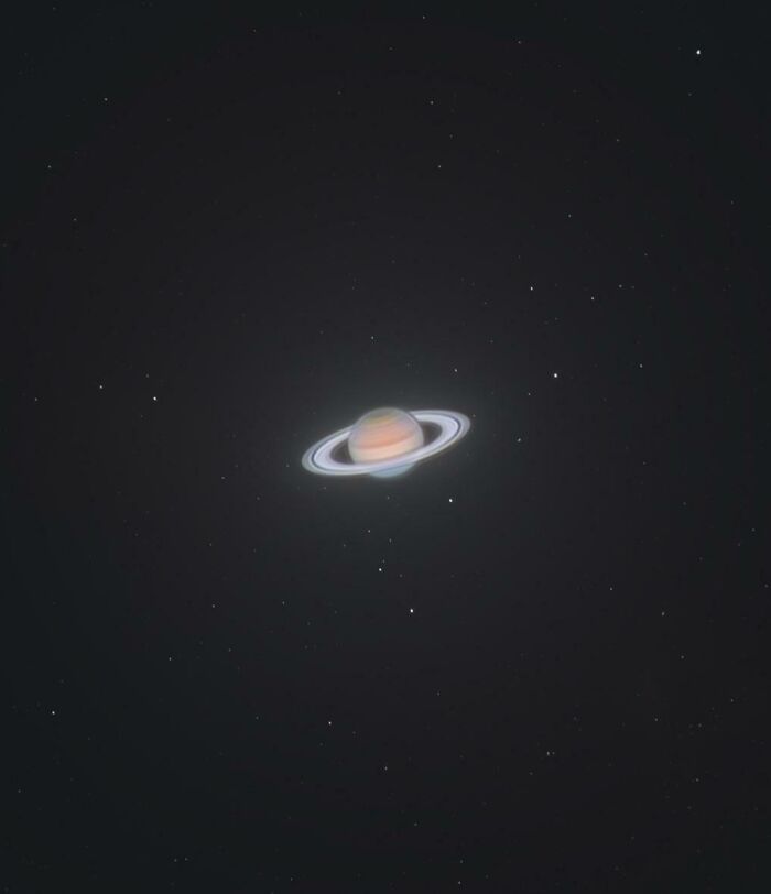 Planeta Saturno con sus anillos visibles en una imagen surrealista del espacio profundo.