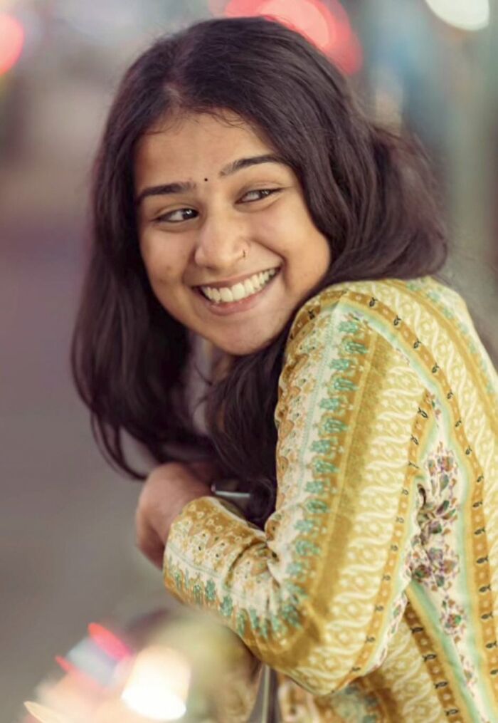Smiling woman in a patterned yellow outfit captured by an Indian photographer, showcasing the beauty of strangers.