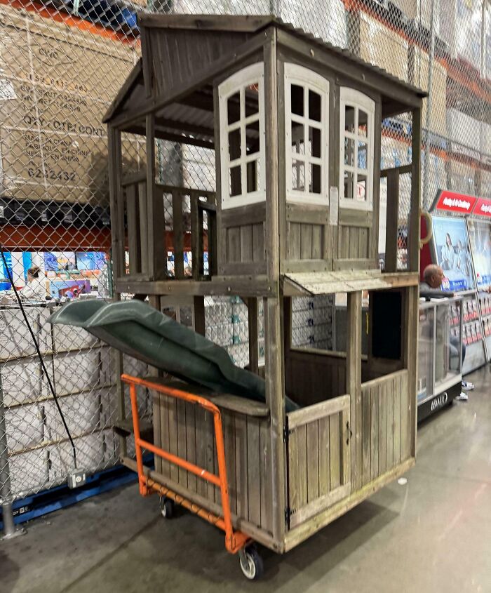 Wooden playhouse on a store cart, surprising item captured for disbelief.