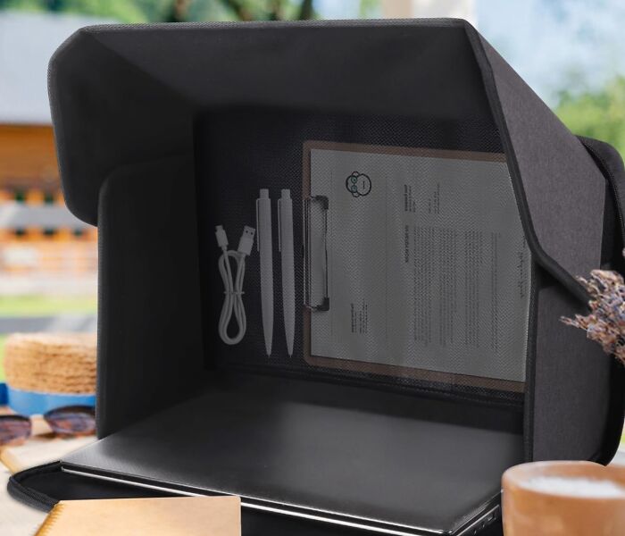 Portable office setup with USB cable, pens, and clipboard inside a privacy tent, showcasing weird productivity hacks.