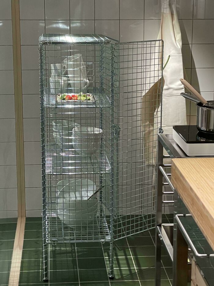Wire storage cabinet with dishes in a kitchen featuring poorly-aging interior design trends to avoid.