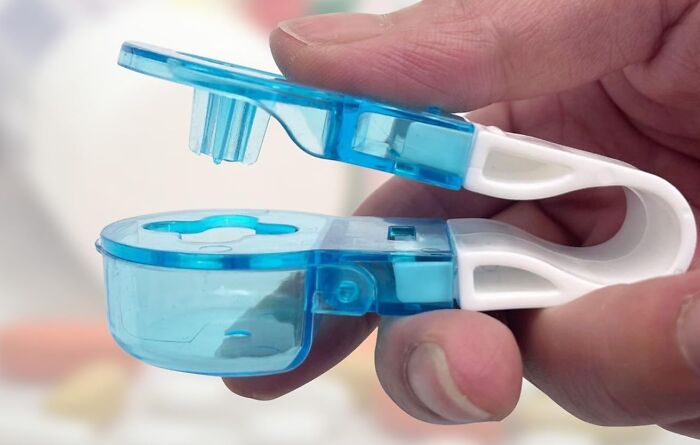 Close-up of a unique tool with a blue and white design held in hand for an unexpected household job.