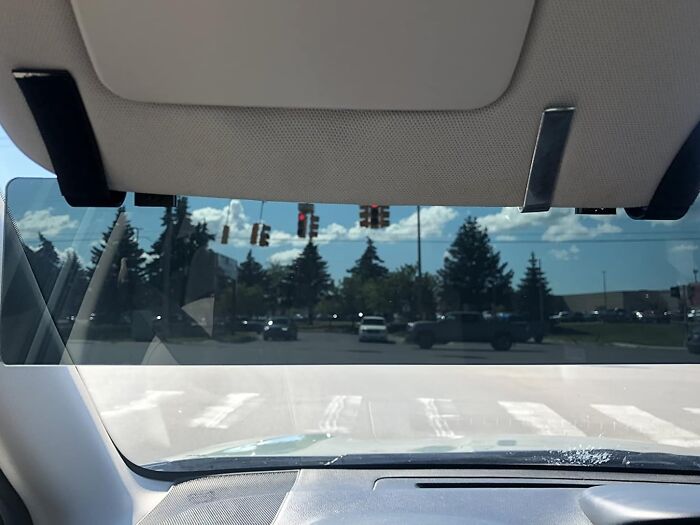 Car sun visor tool for unexpected jobs, reducing glare while driving at an intersection.