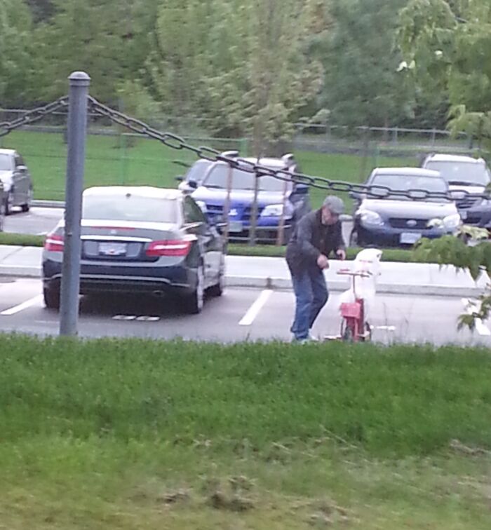 Man painting parking lines on top of parked cars, capturing an unusual moment.