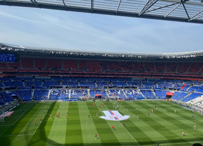 A large soccer stadium with players warming up on the field, showcasing one of the cathedrals of soccer.