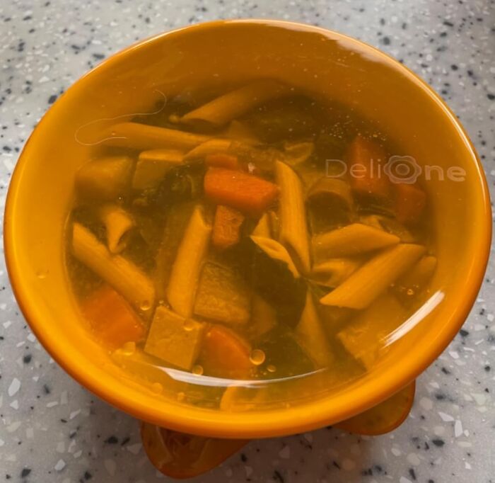 Orange bowl with penne pasta and vegetable soup, simplifying adult life.