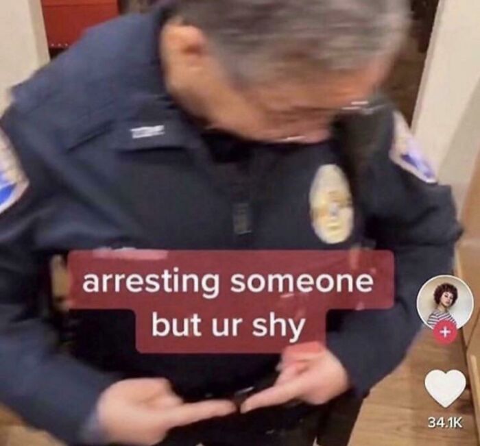 A shy police officer awkwardly buttons their uniform, capturing a moment of cringe.