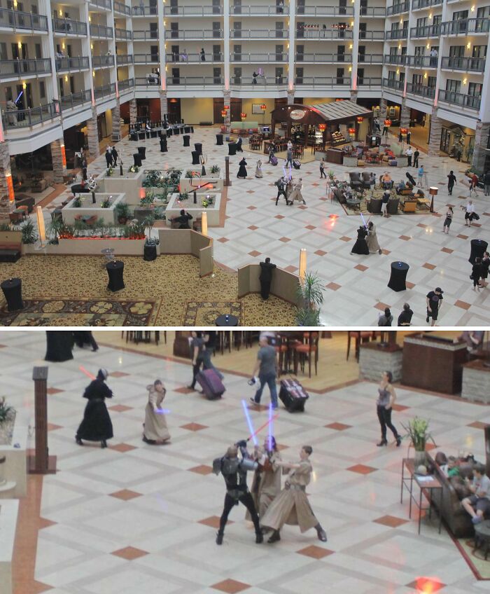 People in costumes having a lightsaber duel in a hotel lobby, capturing an unexpected moment.