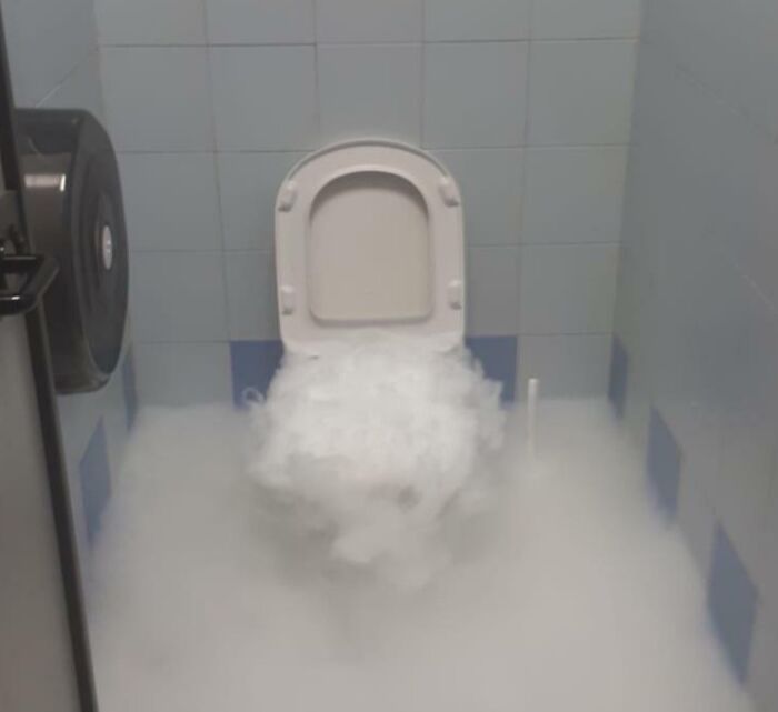 Toilet emitting fog in a bathroom, capturing an unusual sight.