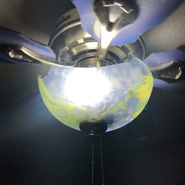 Broken ceiling fan globe with world map design, humorous bad day mishap.