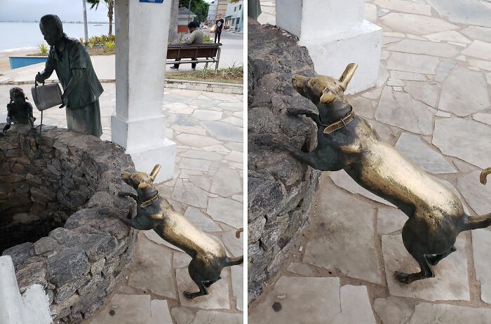 Bronze dog statue with worn patina from time and use, reaching over stone well with a human figure nearby.