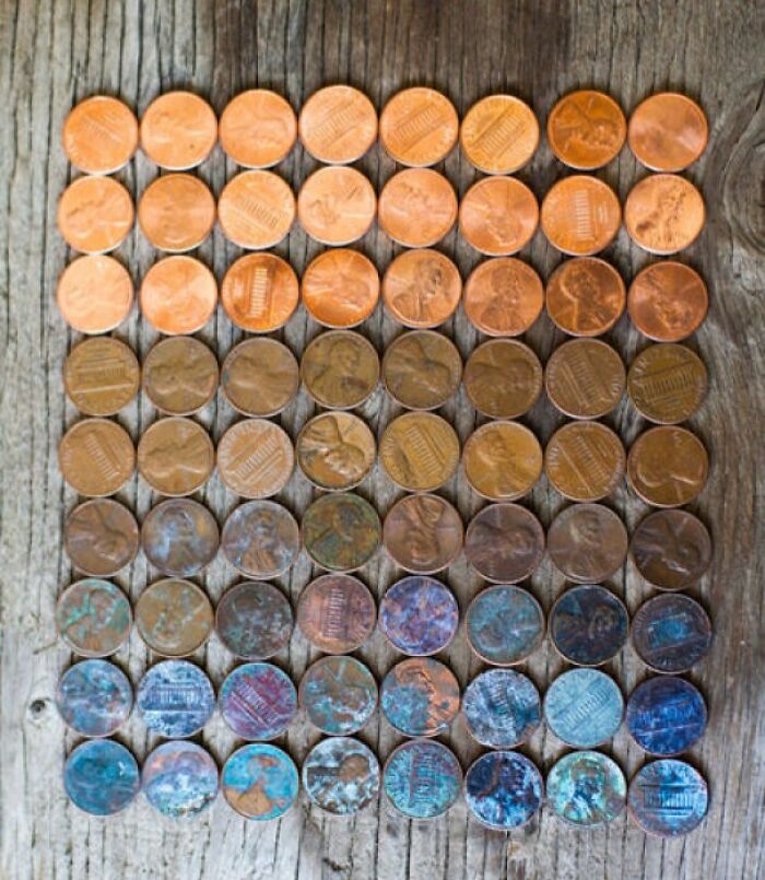 Coins arranged by color transformation over time on wooden surface.