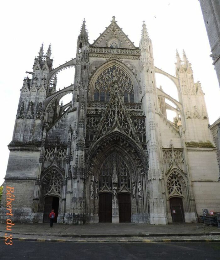Gothic cathedral facade transformed by time, showcasing intricate stonework and weathered architectural details.