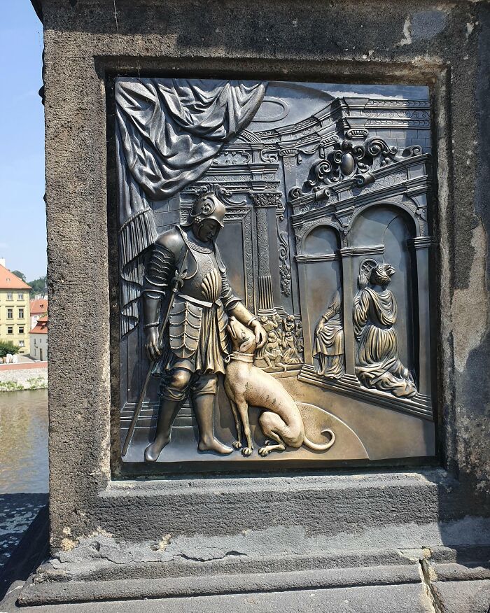 Bronze relief sculpture depicting a knight with a dog, illustrating transformation by time and use.