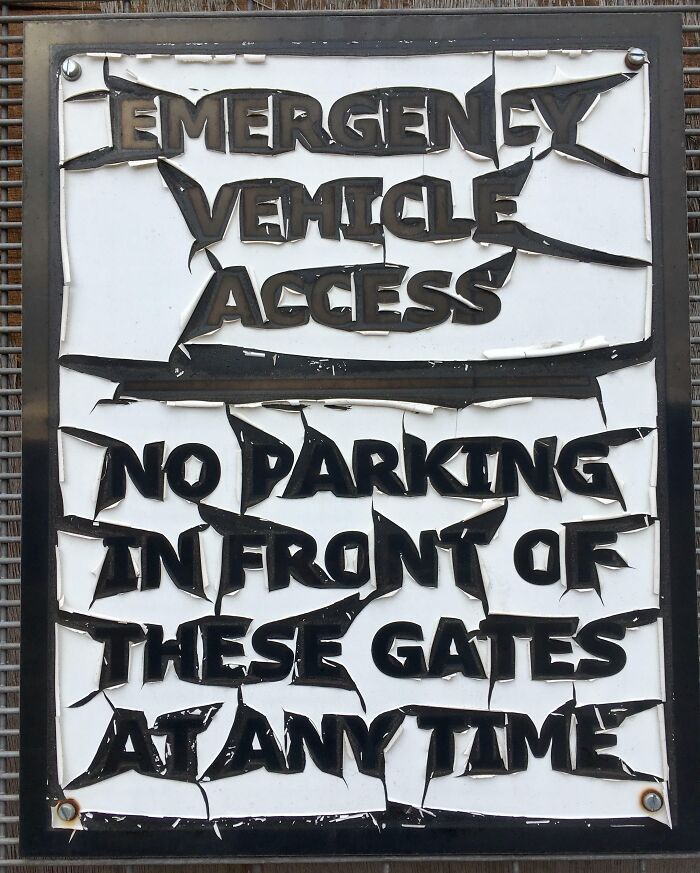 A weathered sign with bold letters, "Emergency Vehicle Access, No Parking," transformed by time and use.