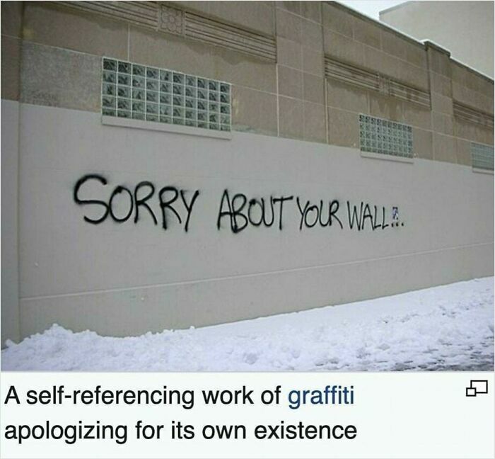 Graffiti on a wall saying, "SORRY ABOUT YOUR WALL," humorously apologizing for its presence.