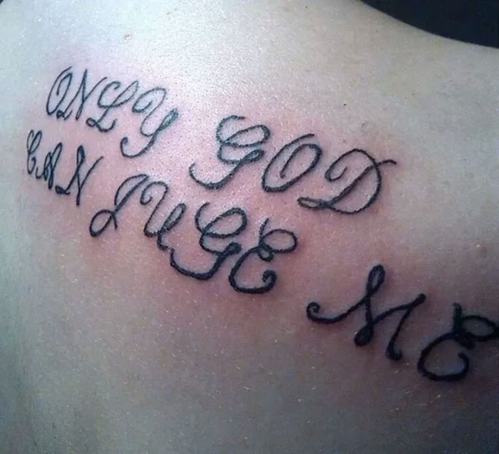 Tattoo with misspelled text "Only God Can Juge Me" on skin, highlighting unattractive ink design.