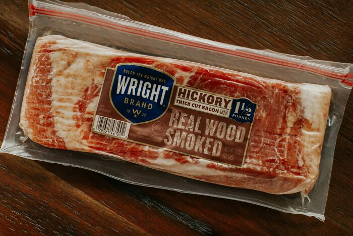 Packaged hickory smoked bacon on a wooden table, an unexpected-cat-gift idea.