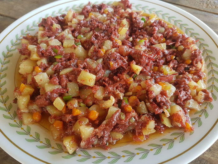 Old-school delicacy: a colorful dish of diced meat and vegetables on a decorative plate.