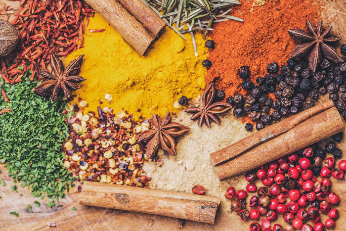 Various spices on a wooden surface, including cinnamon sticks and star anise, used in diverse cooking. Various spices on a wooden surface, including cinnamon sticks and star anise, used in diverse cooking.