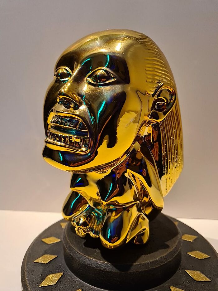 Golden movie prop idol on display with detailed engravings.