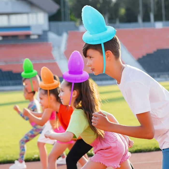 Children enjoy a fun Easter activity with colorful hat-like props at a stadium, showcasing creative Easter ideas.