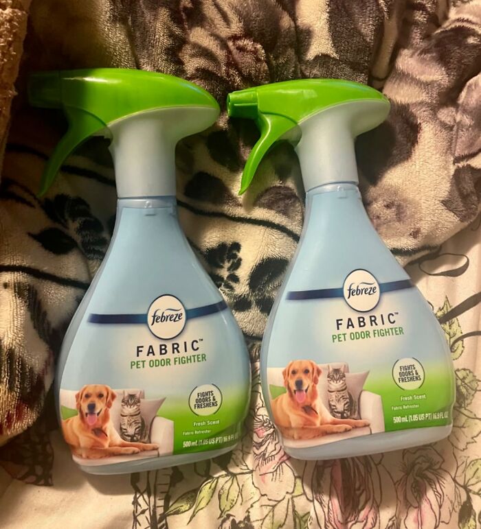 Two bottles of Febreze Fabric Pet Odor Fighter on a floral fabric background.