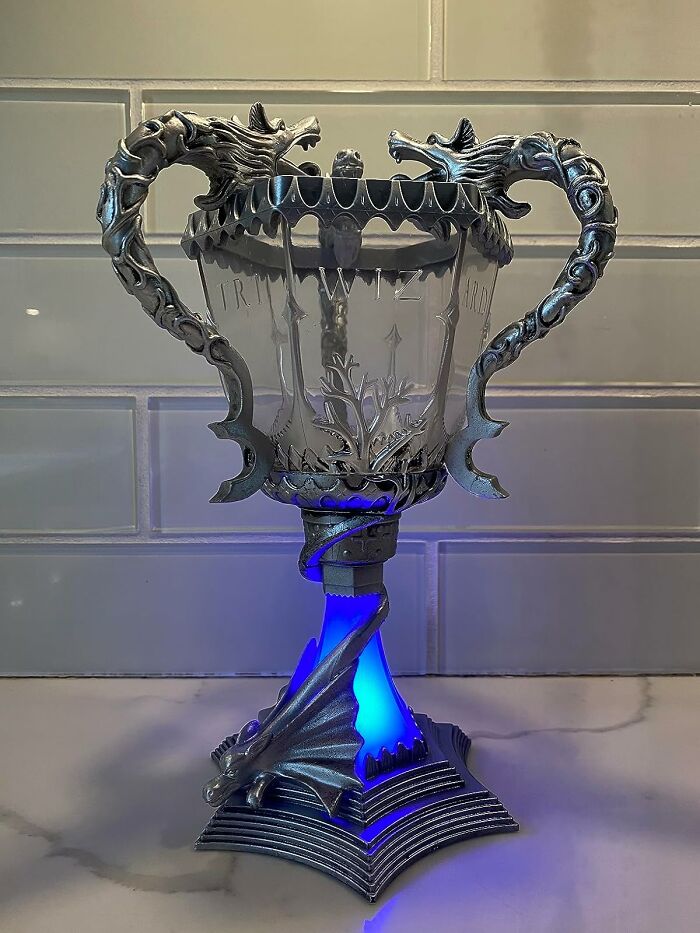 Illuminated movie prop goblet with dragon details, glowing blue.