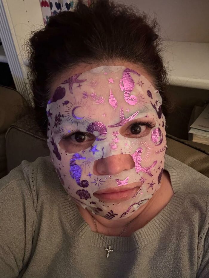 Woman wearing a decorative face mask featuring sea creatures, showcasing bargain beauty products from Amazon.