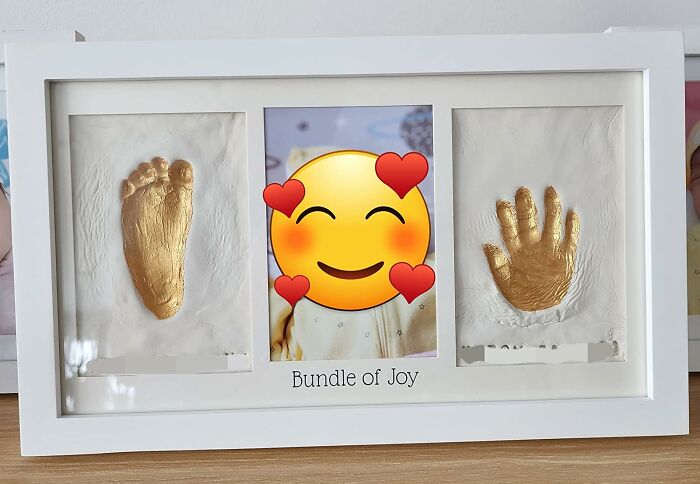 Gold-cast hand and foot prints in a white frame, representing sentimental clutter storage.